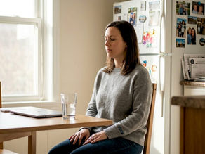 Woman practicing stress management at kitchen table