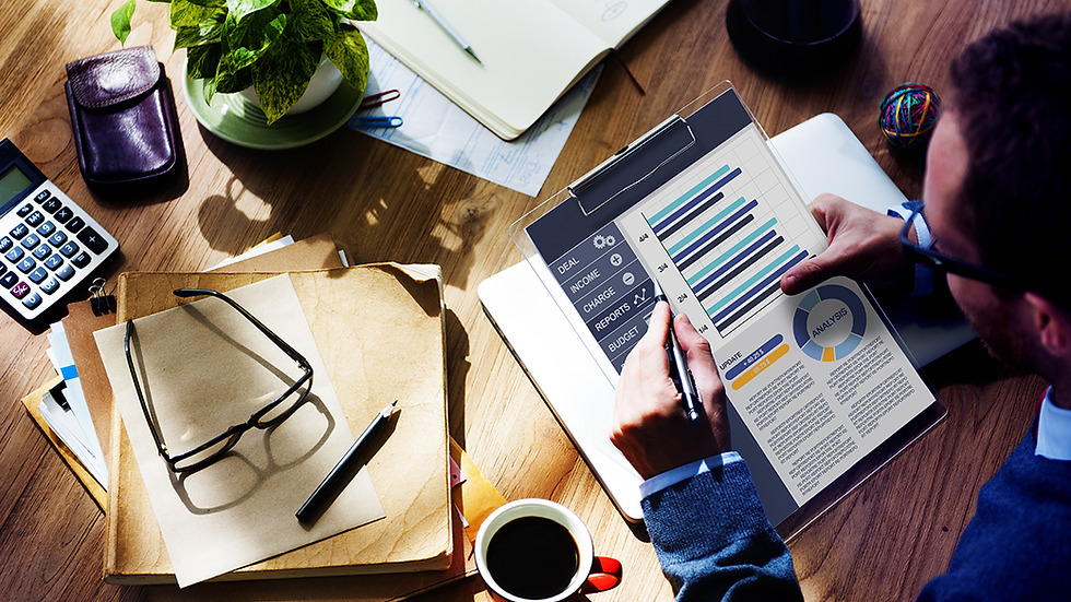 business man working on crowded desk full of marketing materials