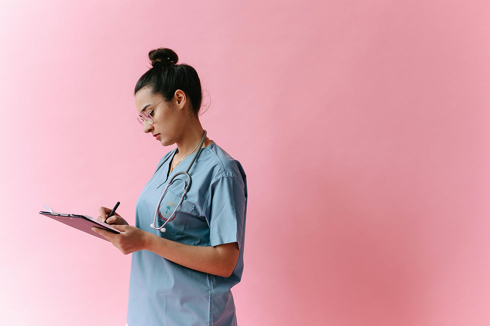 A veterinarian in scrubs writes notes on a clipboard while standing against a pink background, reflecting the pressure, responsibility, and mental load carried by veterinary professionals.