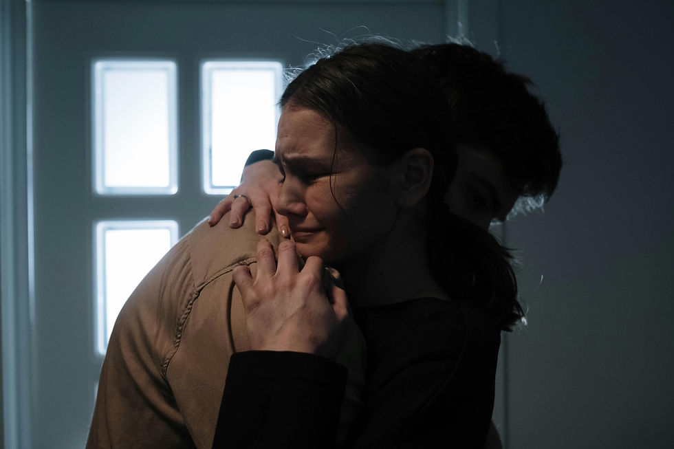 A grieving woman cries while being held in a close embrace by another person, conveying emotional pain, comfort, and support during a time of loss.