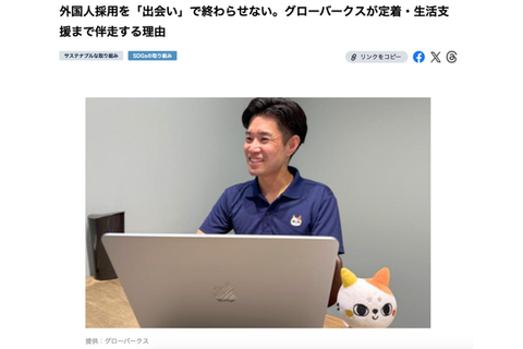 ノートパソコンを前に笑顔で座るグローバークス代表の森永健太。隣にはグローバークスのキャラクターのぬいぐるみが置かれている。