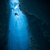 Ice climber desceding into ice cave