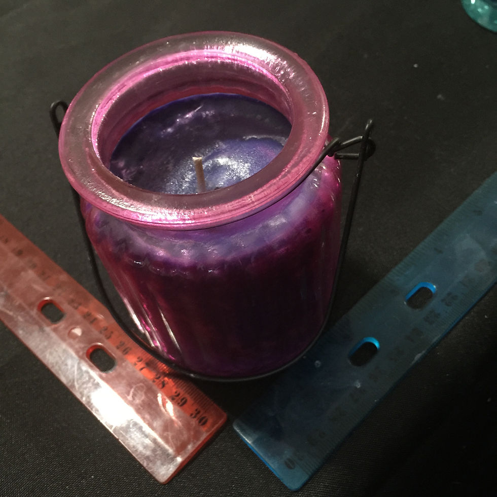 PURPLE JAR WITH HANDLE WITH BLUE CANDLE.