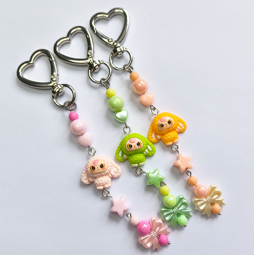 Three colorful handmade keychains with cartoon charms