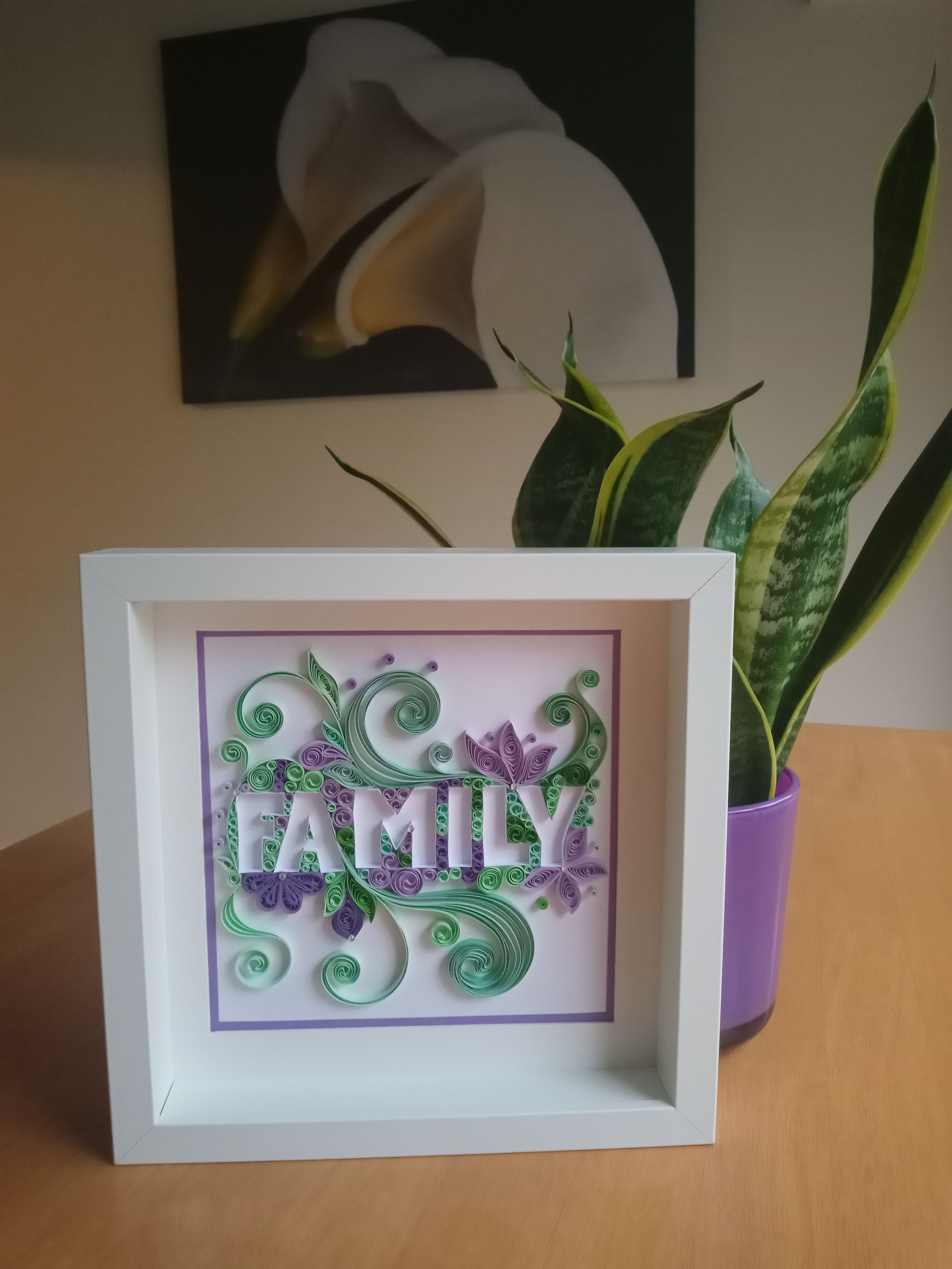 White framed picture with 'FAMILY' in green and purple swirls
