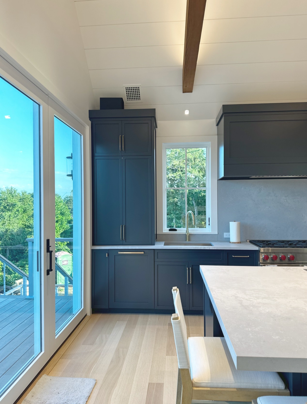 Contemporary kitchen showcasing stylish cabinets and creative lighting, highlighted by an open layout and scenic views through expansive sliding doors.