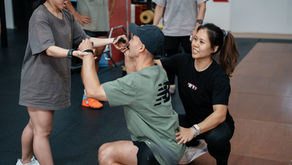 Coaches assist a member doing squats in the Rx Performance gym in Singapore