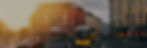 A yellow tram is on a street in a city with cars.