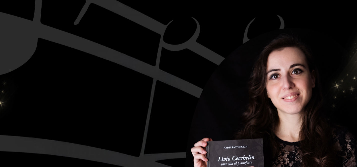 la foto di Nadia Pastorcich per la presentazione del suo libro “Livio Cecchelin, una vita al pianoforte”. Lei è sorridente, lo sfondo è nero con delle note su un pentagramma. La presentazione del libro si è tenuta al Teatro Bobbio de La Contrada Trieste