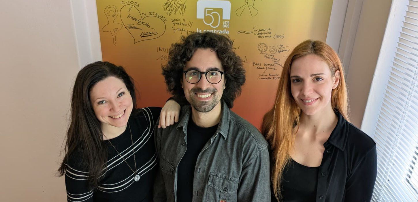 Cuore di Stagno è la residenza Artistica de La Contrada, teatro di Trieste. I tre attori sono di fronte ad un muro colorato di giallo e rosso con il logo della contrada e le firme dei partecipanti alle residenze contrada