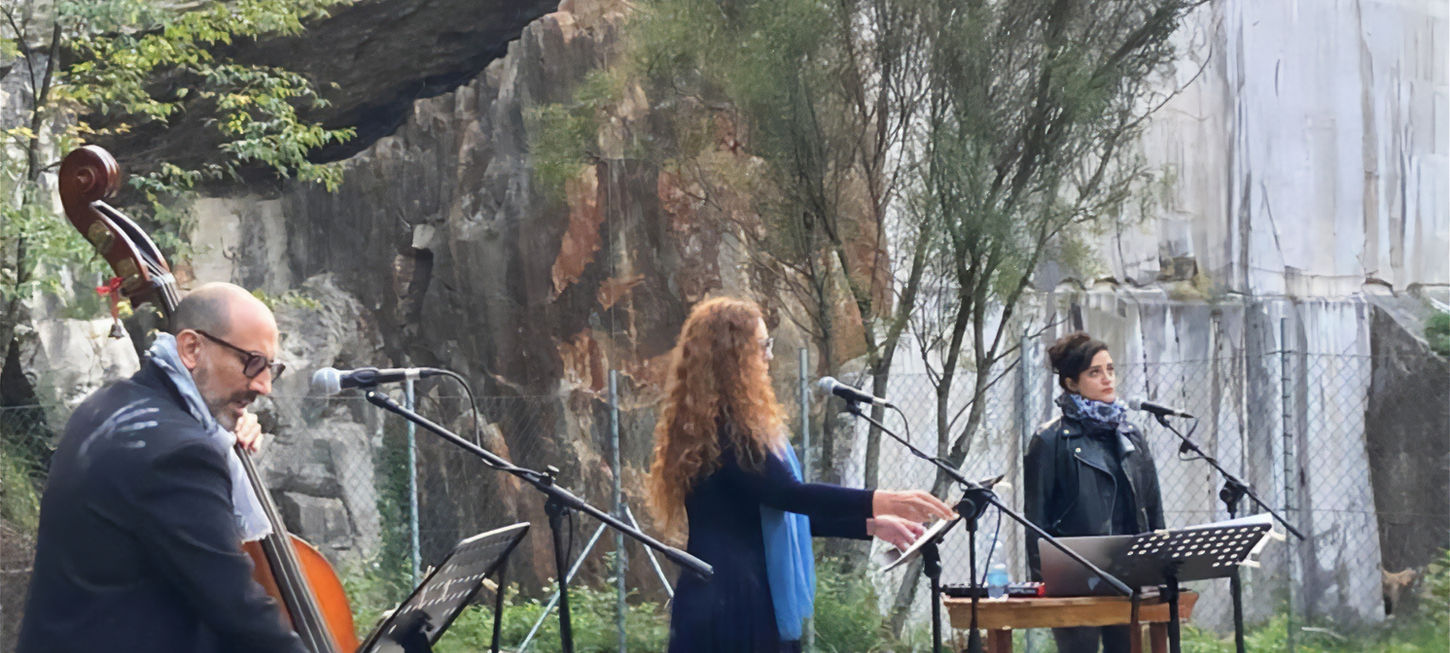 la foto dell'evento Su Questo Lembo di Terra Pietrosa, ci sono Valentino Pagliei al contrabbasso, Elena Husu in centro ed Enza De Rose a destra. Sullo sfondo le Cave di Aurisina. uno spettacolo che andrà in scena al Teatro Bobbio de La Contrada di Trieste