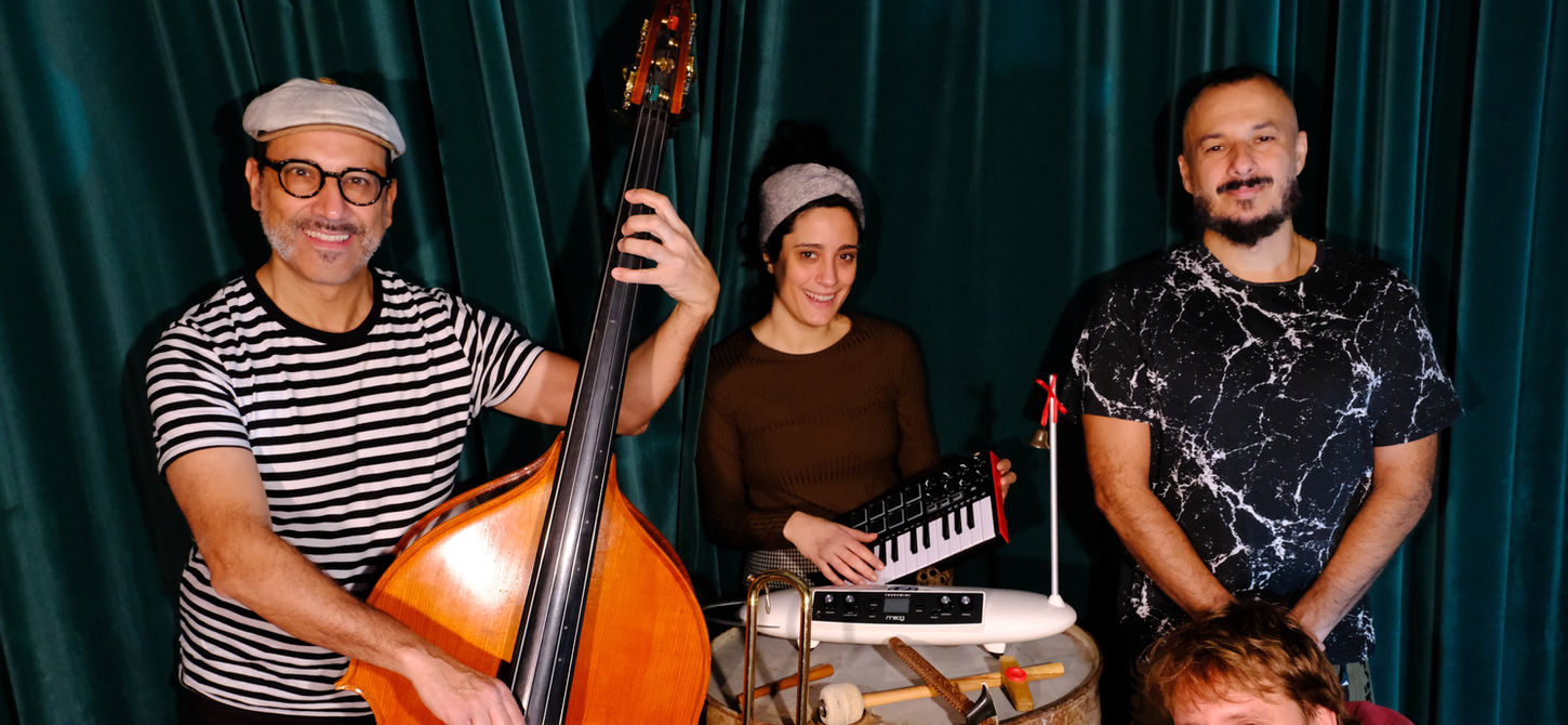 Giulio Settimo, Enza De Rose, Valentino Pagliei e Francesco Paolo Ferrara in Il Brutto Anatroccolo, nuova produzione di teatro ragazzi del Teatro La Contrada. Foto con strumenti musicali e sfondo con una tenda blu