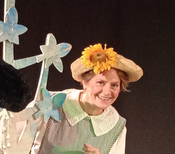 Nella foto Daniela Gattorno ha un cappello con un fiore sopra e un cesto in un braccio. Lo sfondo è scuro. Lo spettacolo andrà in scena al Teatro Bobbio de La Contrada di Trieste