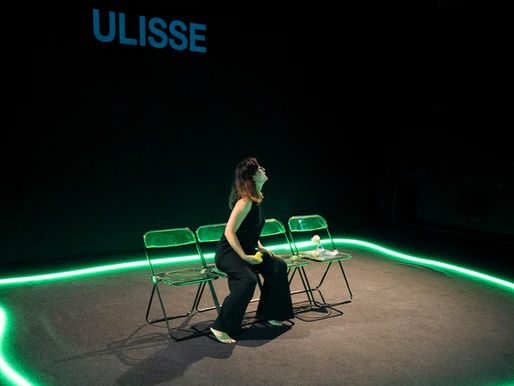 Paola Fresa in P come Penelope. L'attrice, vestta di nero, è seduta in mezzo alla scena, sul pavimento intorno a lei c'è un led verde, il resto della scena è buia. Lo spettacolo andrà in scena al Teatro dei Fabbri de La Contrada Teatro Stabile di Trieste