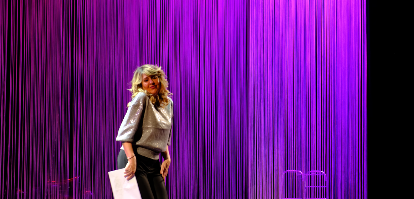 immagine con la foto di Emanuela Grimalda in scena, con una luce viola. Lo spettacolo è una produzione Teatro Bobbio de La Contrada Teatro Stabile di Trieste