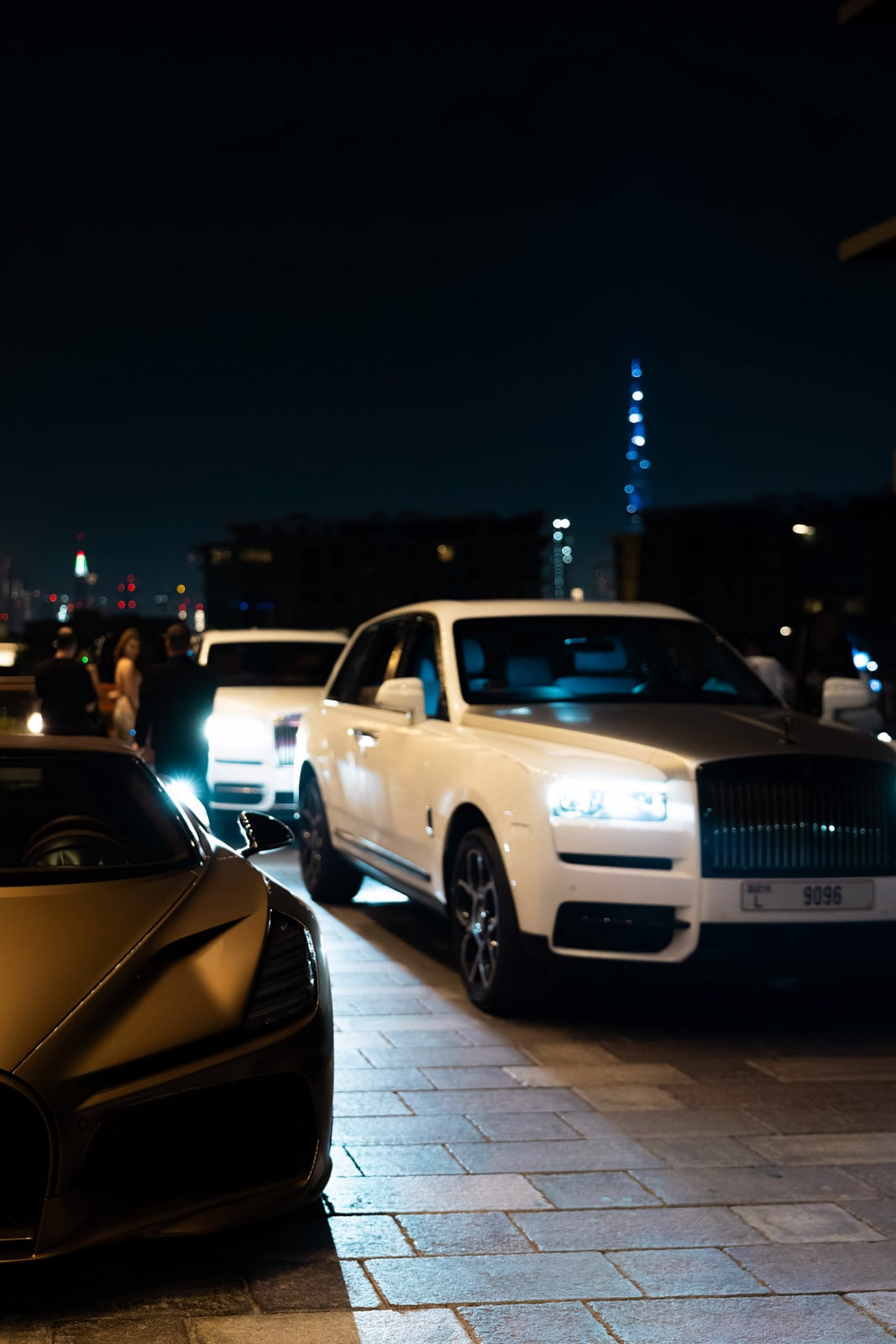 A Rolls-Royce arriving beneath city lights