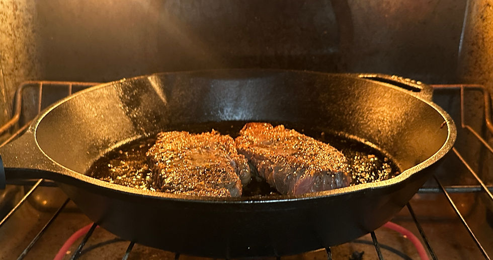 Juicy steaks sizzling in a cast iron skillet, finishing to perfection in the oven.