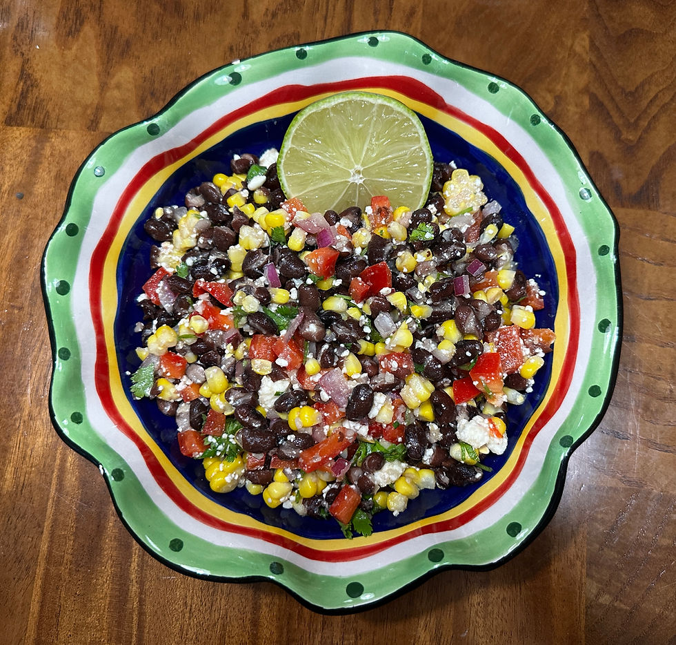 Colorful and refreshing, this fiesta black bean and corn salad is beautifully presented in a vibrant dish, accented with a fresh lime garnish.