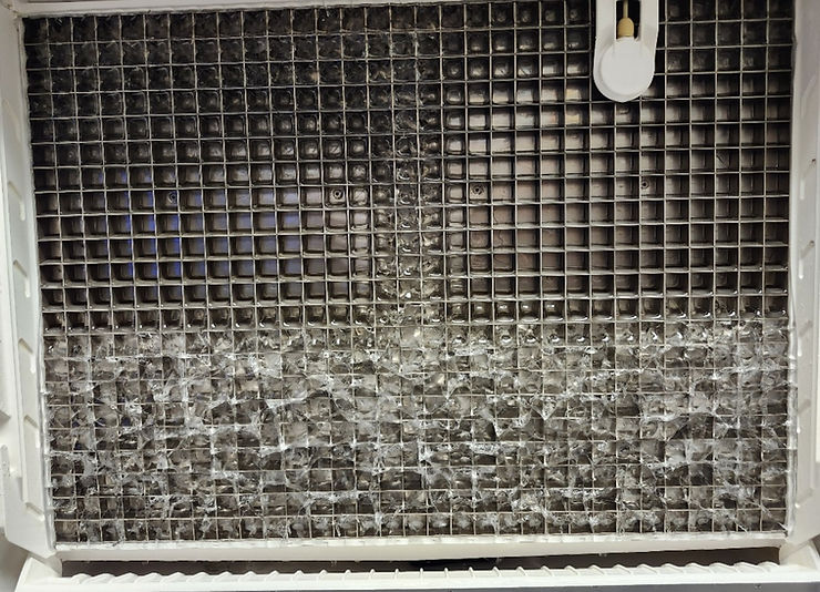 Close-up view of ice machine condenser coils being cleaned