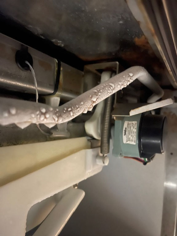 Close-up view of commercial ice machine evaporator with frost formation