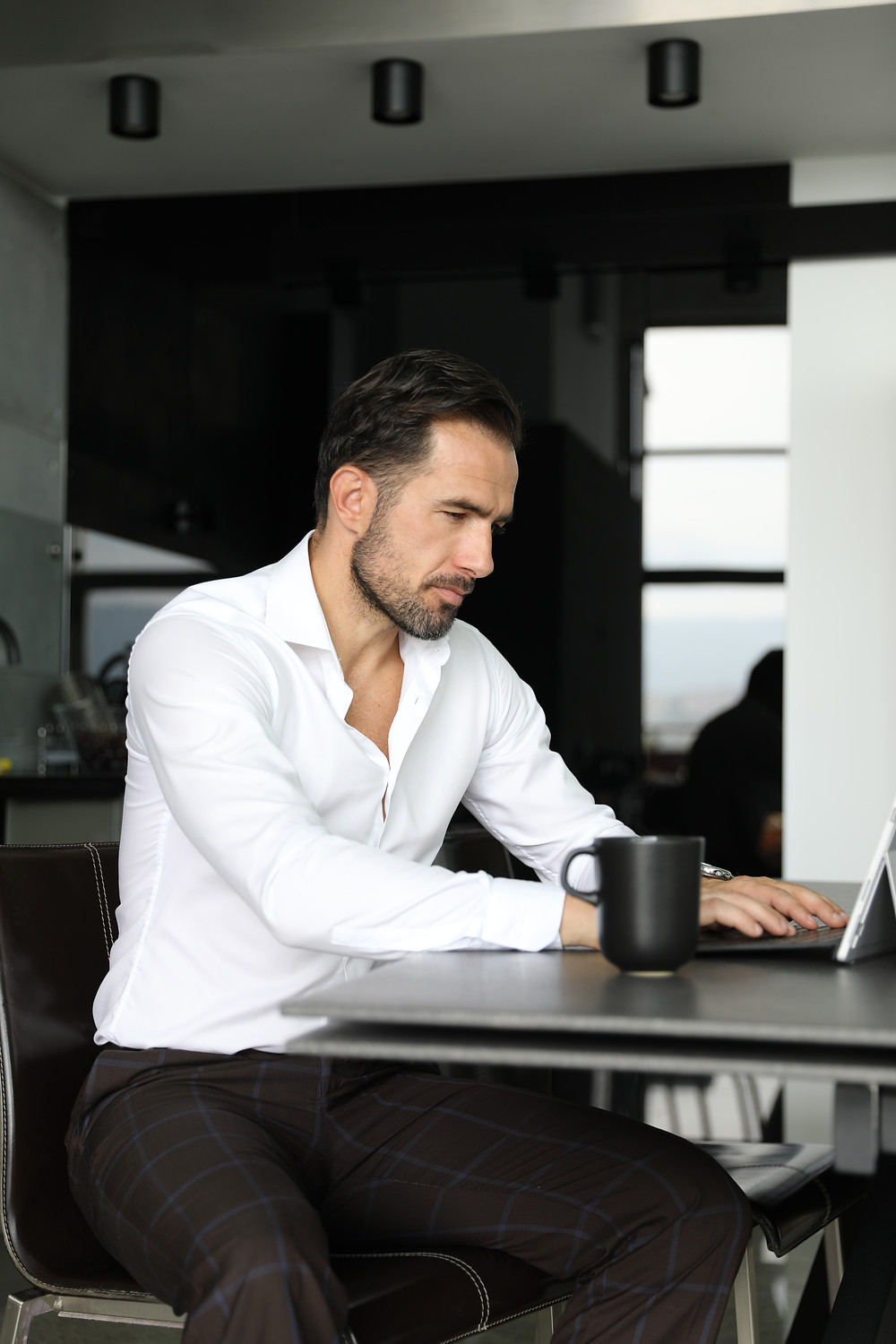 Mężczyzna pracujący na laptopie, siedząc przy biurku