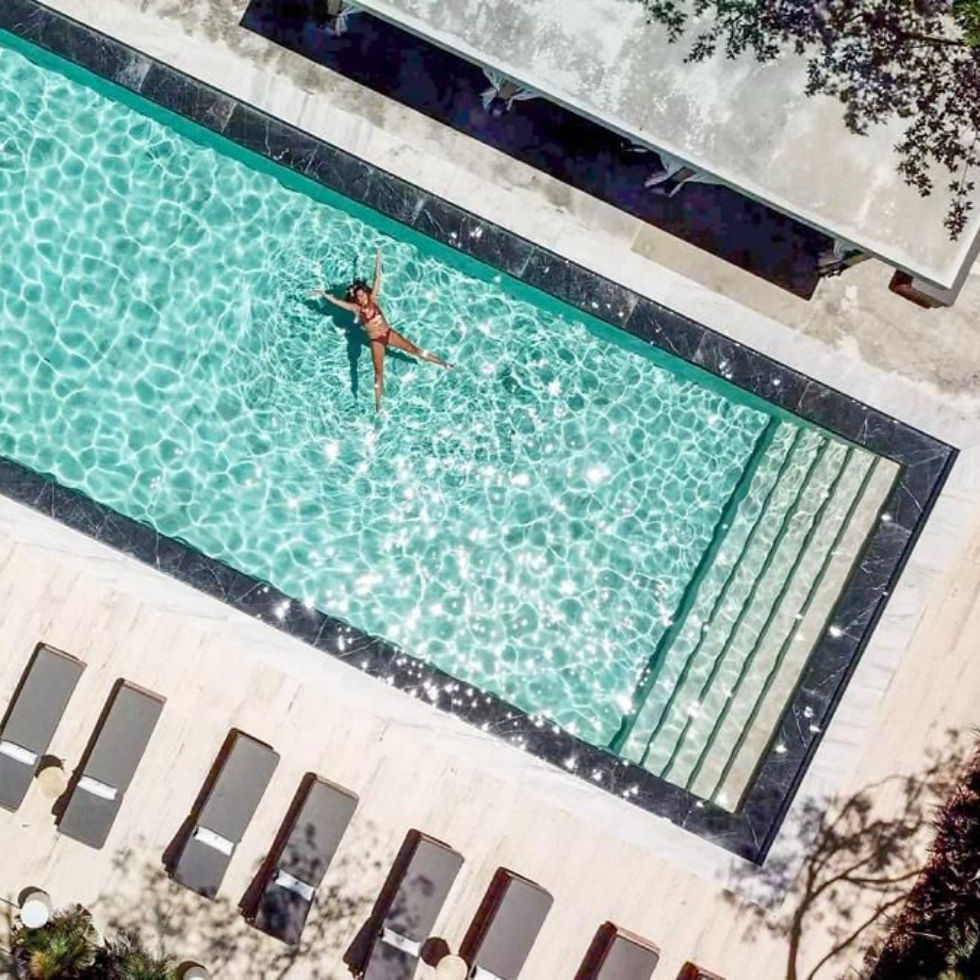Woman floating in a luxury real estate Riviera Maya pool.