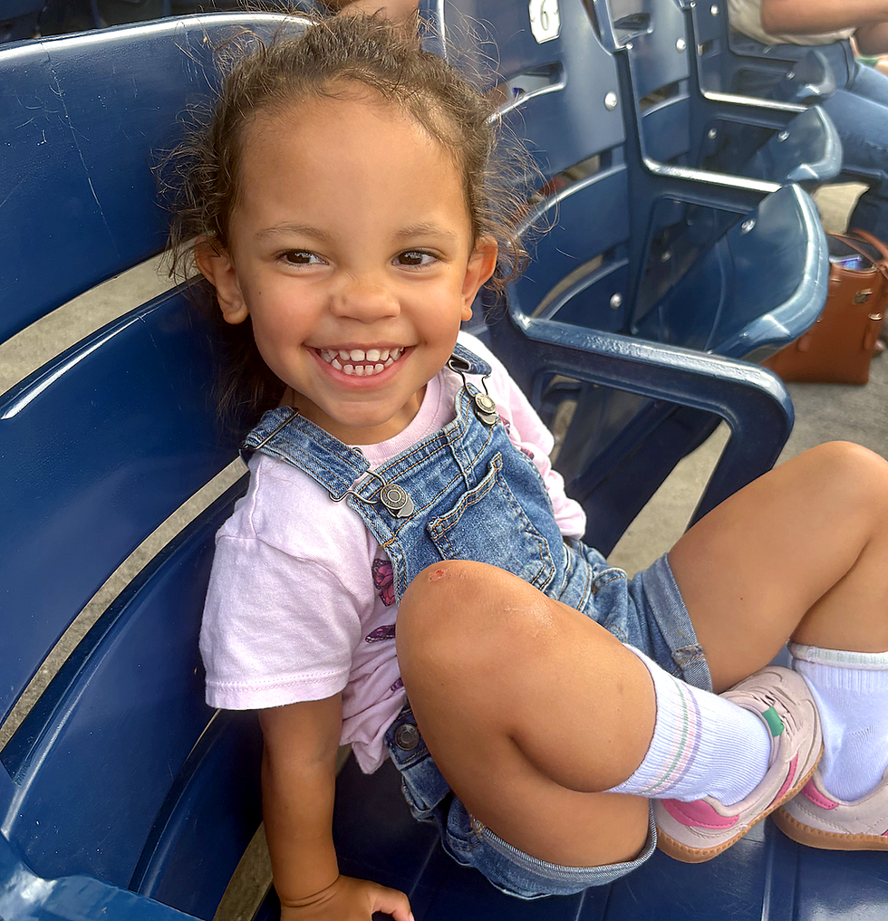 child sitting in their seat at a baseball game