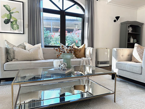 formal lounge using neutral tones and glass and metallic coffee table