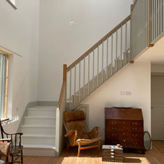 Interior of accessible residential home in Barrington, Cambridge, featuring timber flooring, white staircase, and natural light, designed by Haysom Ward Miller Architects.