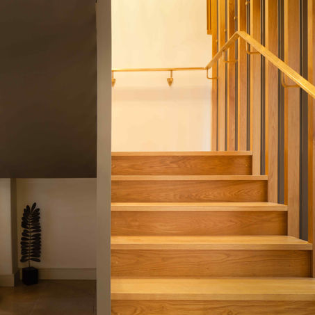 Timber staircase with brass handrail in the Boxworth, Cambridgeshire residential barn conversion by Haysom Ward Miller Architects, showcasing craftsmanship and modern architecture.