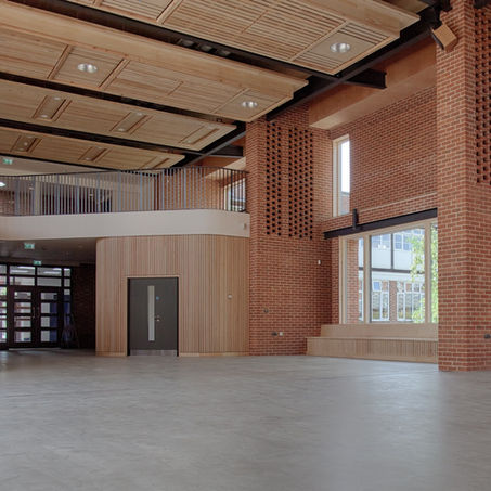 Award-winning interior of Radegund Hall at Coleridge Hall, Cambridge – school architecture by Haysom Ward Miller Architects, winner of Best New Building over £1 million at the Cambridge Design & Construction Awards 2013, featuring exposed brick walls, timber staircase, slatted timber wall panels, and high-performance sustainable materials.