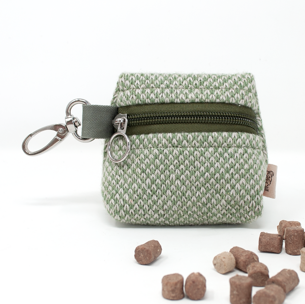 Green dog treat pouch with black zip and dog treats
