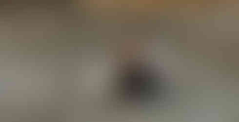 a couple sitting and giggling in the sand on the beach