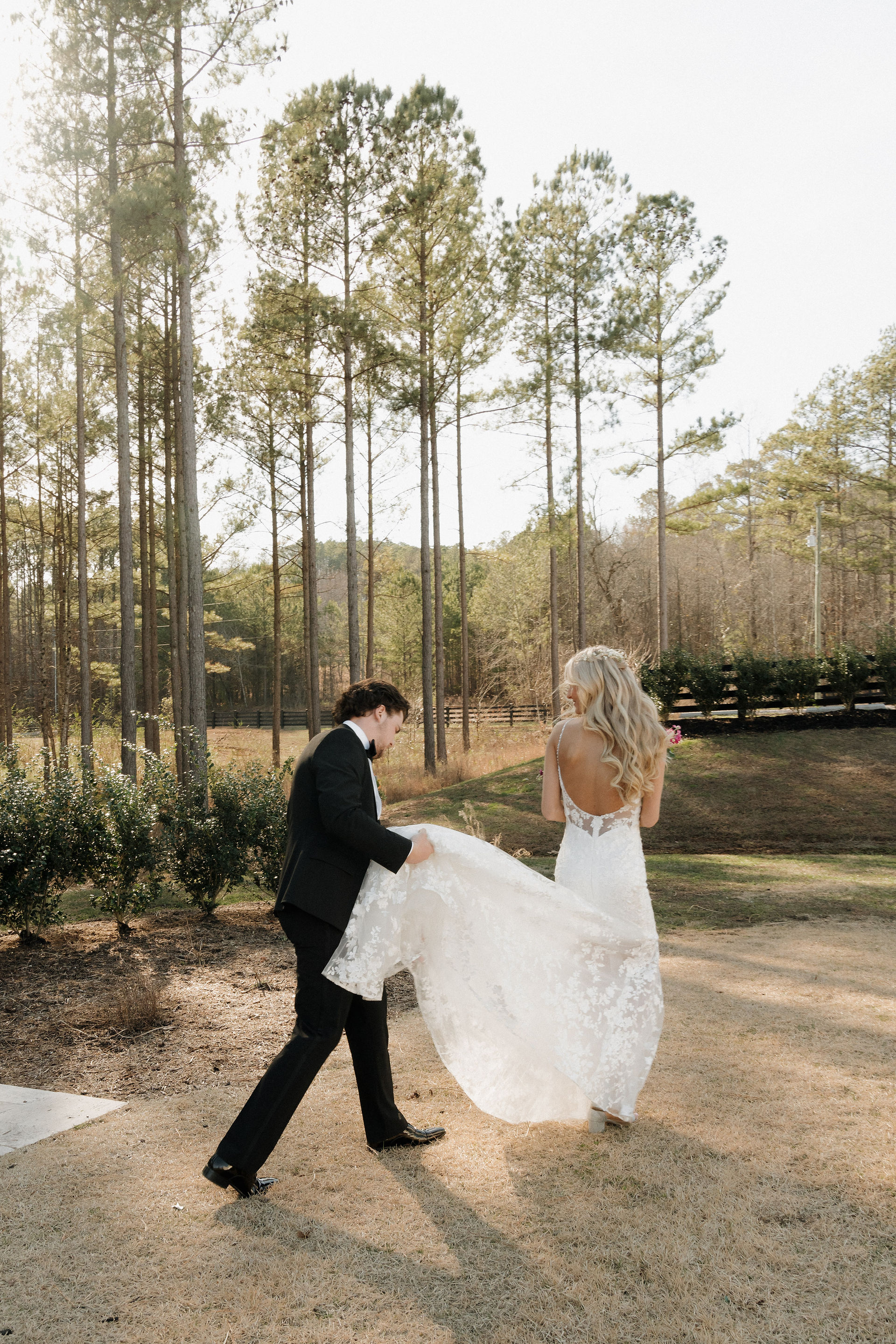 groom helping bride with dress