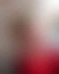 Senior boy smiling while leaning against a brick wall for Senior session