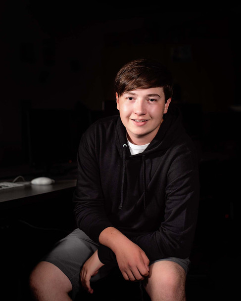 Gretna High School Senior boy smiling in front of desktop computers