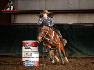 A gal turns her horse around the first barrel during a barrel race at Kiplinger Arena.
