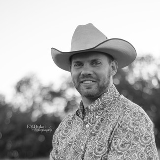 black & white image of cowboy smiling at the camera