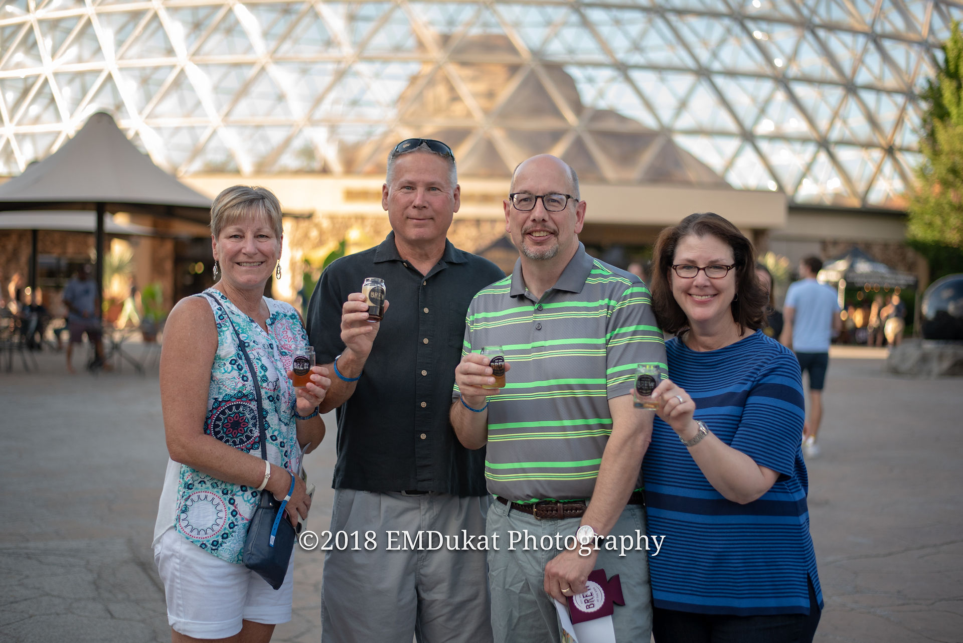 participants smile with their shot glasses outside the Desert Dome during brew at the zoo at Omaha's Henry Doorly Zoo
