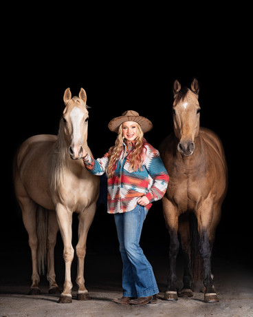 Girl in western wear standing next to two Quarter Horses in stable photo session in Ashland, Nebraska. 