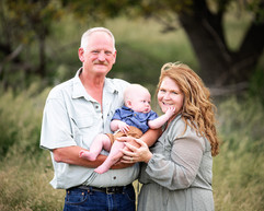 Proud grandparents holding new grand baby for extended family event.