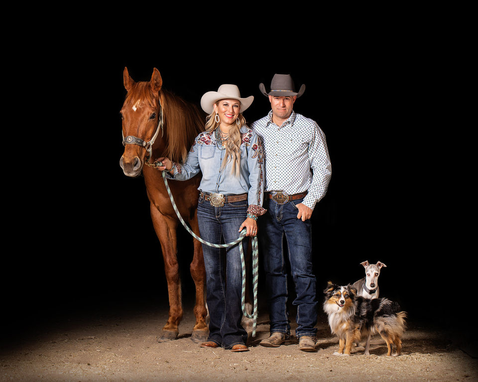 Milliman Quarter Horses huband and wife team pose with horse and two dogs.