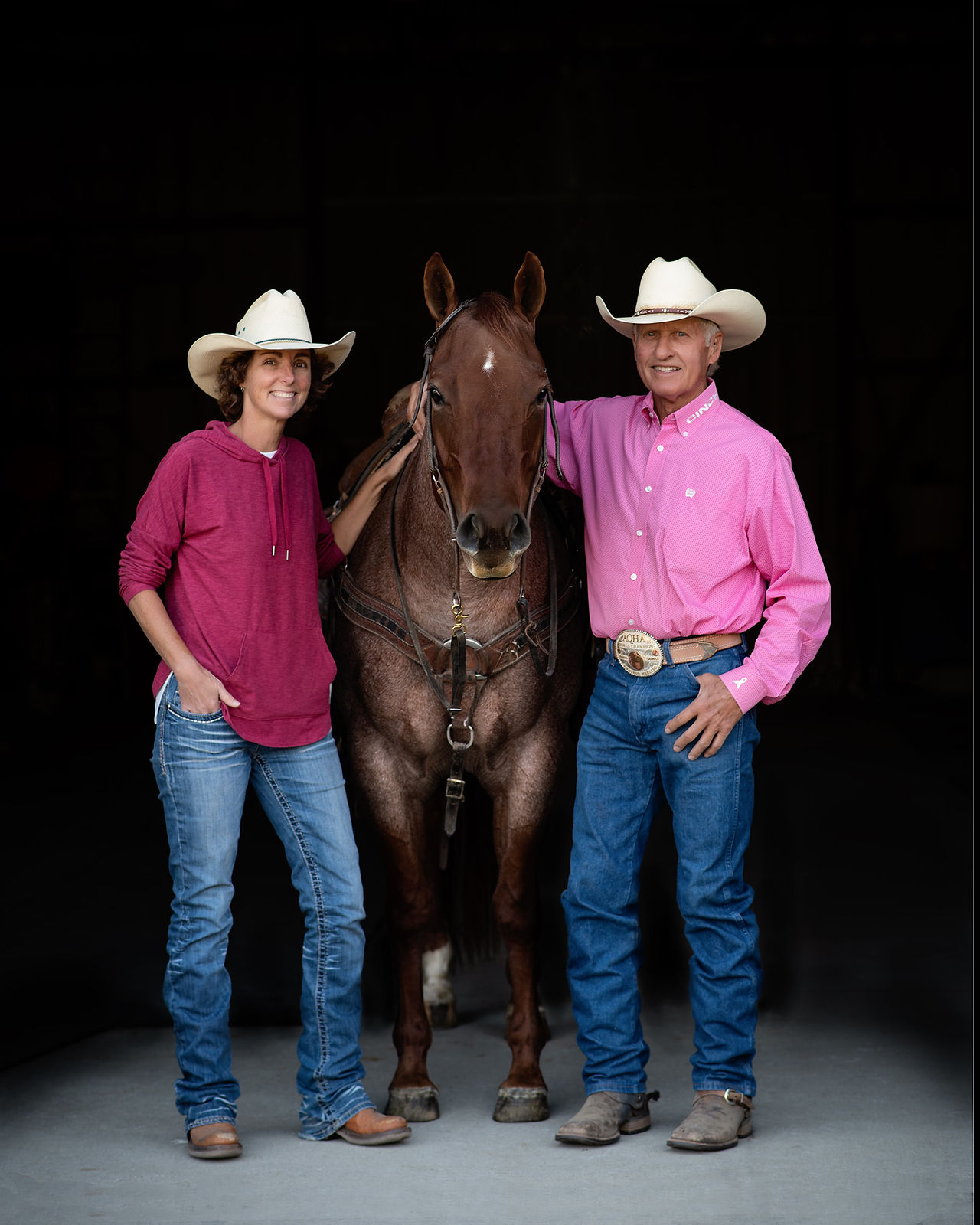 Husband and wife with horse in black background 