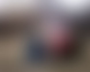 Older siblings laugh while hugging for a holiday family photo.