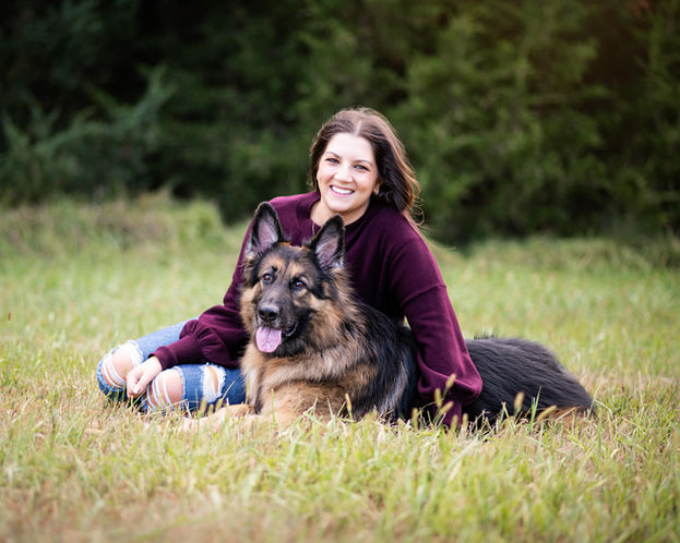 German Shepard sits with her human owner for a pet portrait.