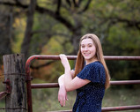 Girl holding onto gate for senior portraits