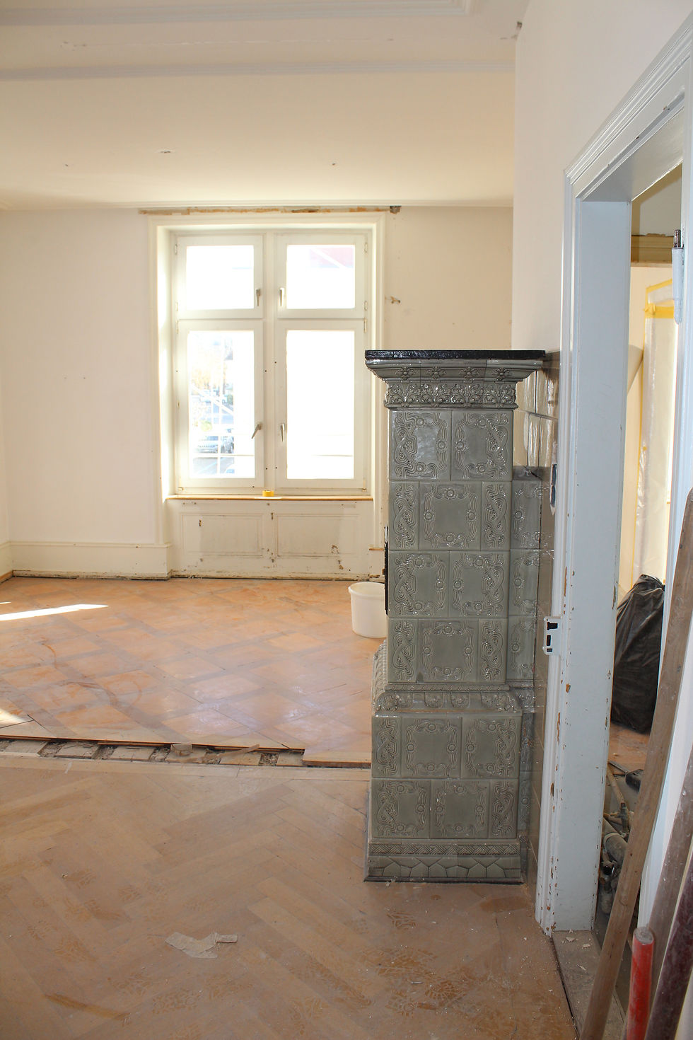  grauer Kachelofen, mit Holz rückseitig befeuert