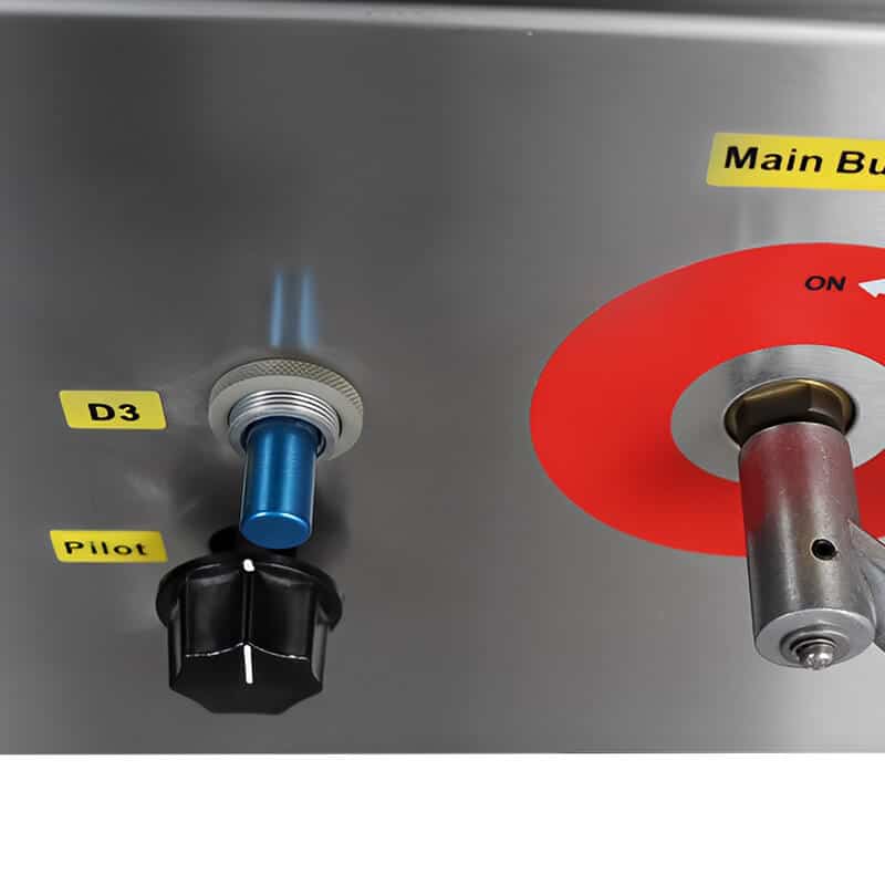 Close-up of wok burner controls and pilot