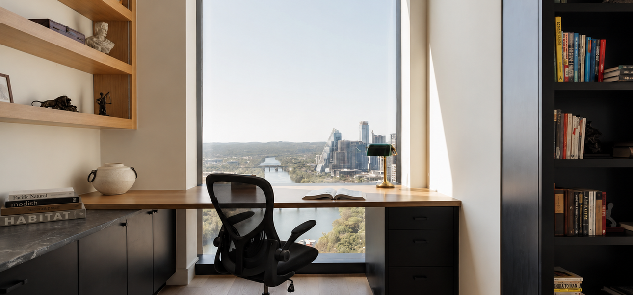 Custom home office with walnut built-in cabinetry, floating desk, open shelving, and downtown Austin views designed by Elm Haus.