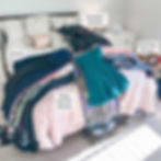 Clothes on a bed for a wardrobe declutter